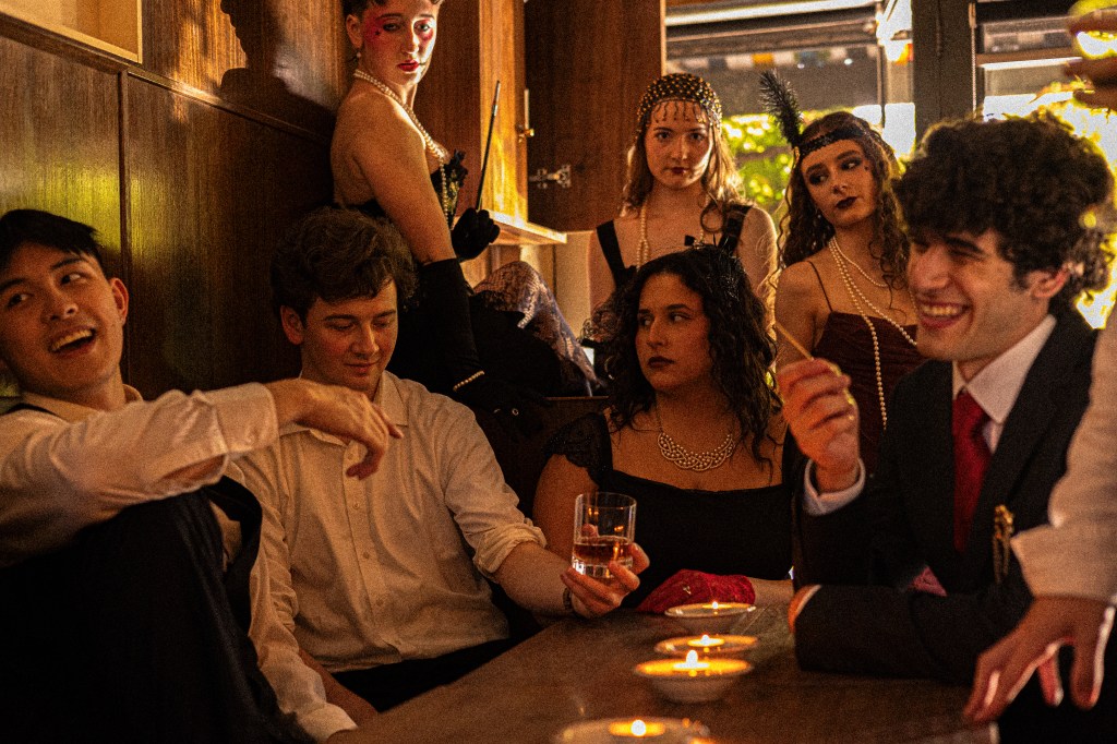 An image of the Macbeth cast in costume at a dimly lit bar